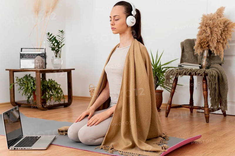 Woman meditating home with headphones