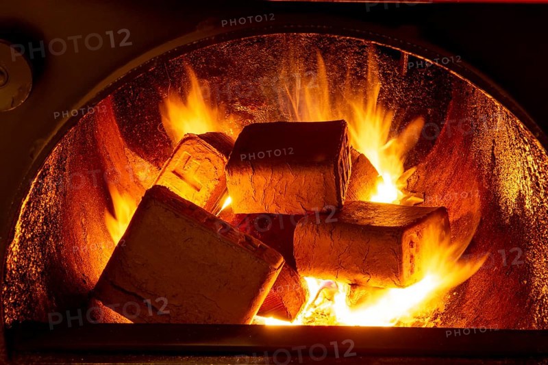Wood briquettes (ruf type), made of beech and oak burning inside the wood fuel boiler. Alternative fuel, eco fuel, bio fuel