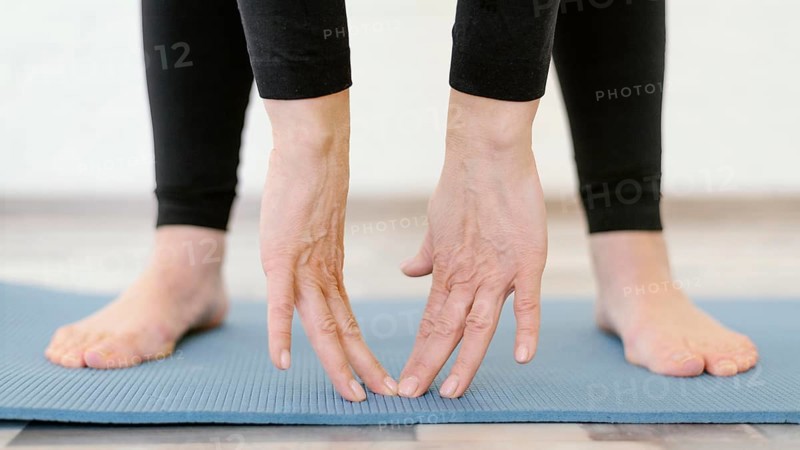 Close up hands touching yoga mat