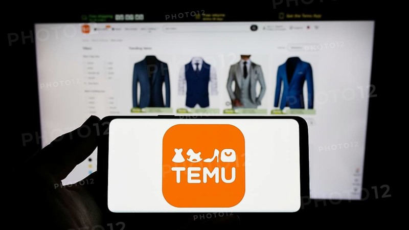 Stuttgart, Germany, 03-18-2023: Person holding smartphone with logo of US online shop company Temu on screen in front of website. Focus on phone display, Europe