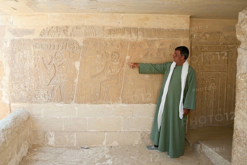 Tourist guide shows relief in Mastaba, near Sakkara, Egypt, Africa