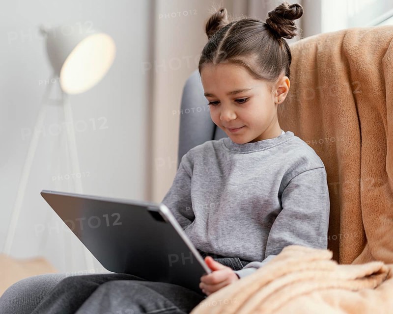 Little girl couch using tablet