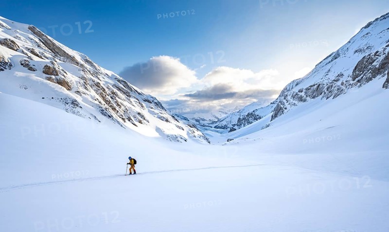 Ski tourers ascending through untouched fresh snow, snow-covered mountain landscape with blue sky and clouds, ski tour on the Wildhorn, Bernese Alps, Switzerland, Europe