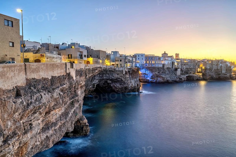 Polignano a Mare with its houses directly on the cliffs after sunset