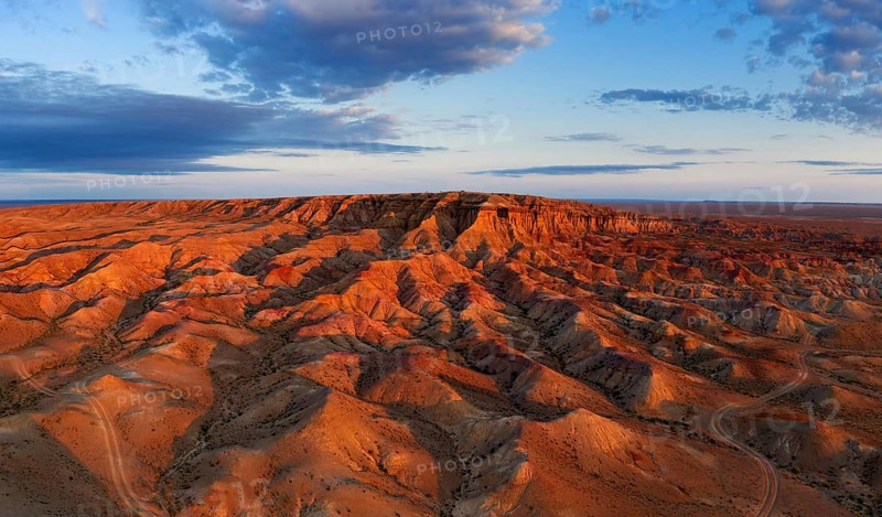 Aerial panorama of textural colorful striped canyons Tsagaan suvarga, White stupa at sunrise. Ulziit soum, Dundgovi province, Mongolia, Asia