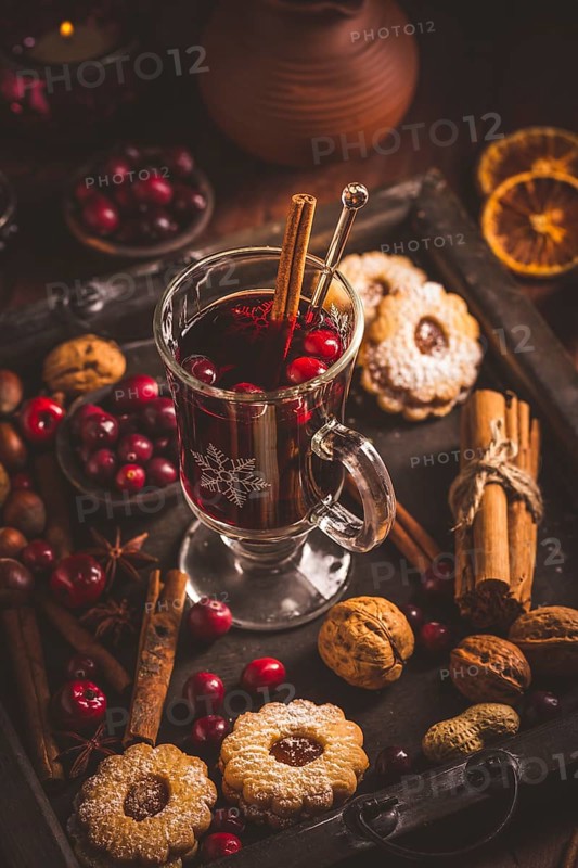 Mulled wine with cranberry and spices, Christmas cookies and candles