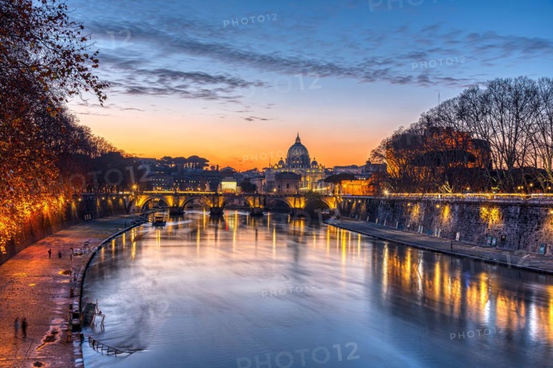 Dramatic sunset over the Basilica of St. Peter and the Tiber in Rome