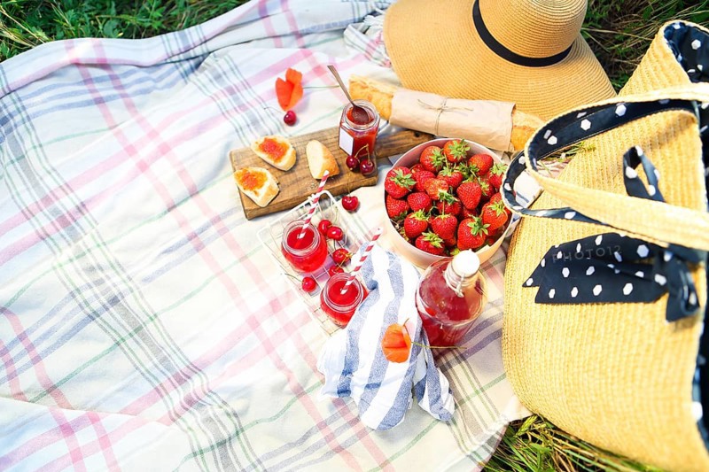 Basket, sandwiches, plaid and juice in a poppy field. Vintage tender background. Romance, love, date