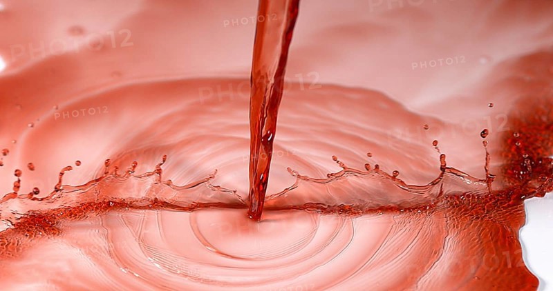 Red Wine being poured against White Background