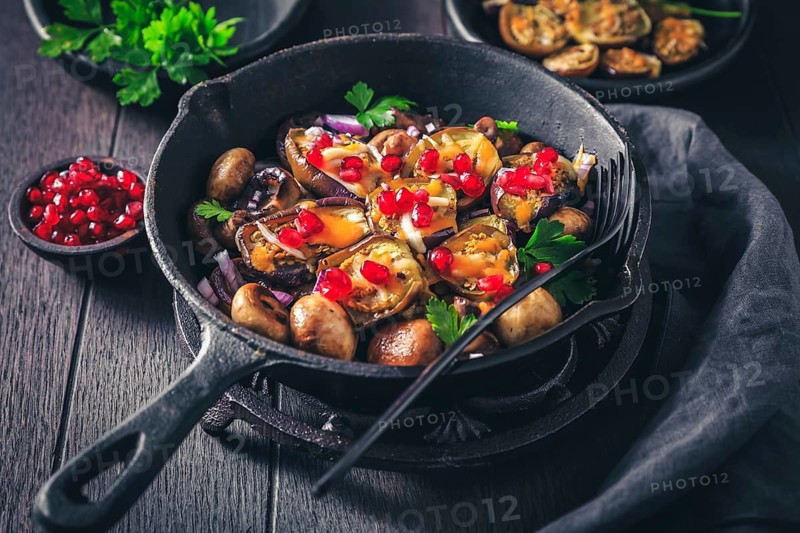 Baked small eggplants, stuffed with mushrooms and pomegranate in baking pan