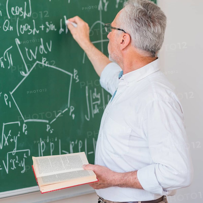 Serious lecturer glasses chalking formula blackboard