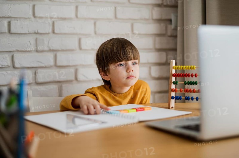 Front view child desk learning from laptop