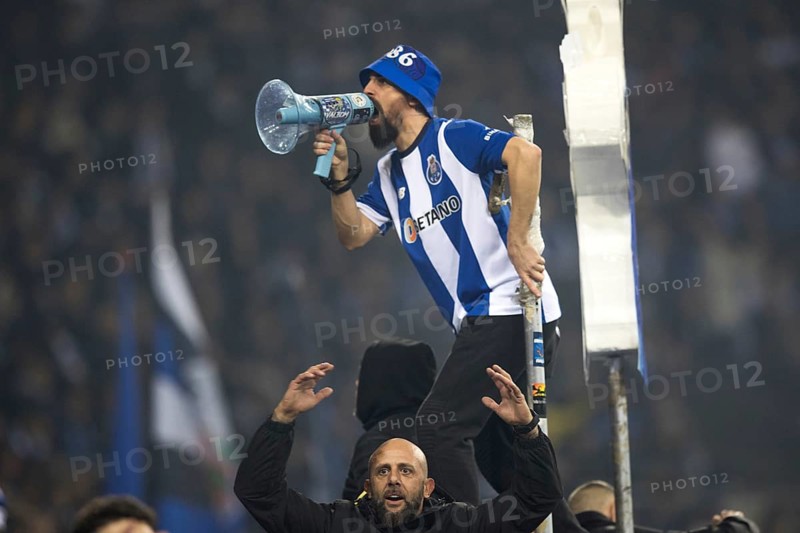 Football match, a fan of FC Porto with jersey on the fence shouting with a megaphone, another fan of FC Porto below with raised arms and in a cheering mood, football stadium Estadio do Dragao, Porto, Portugal, Europe