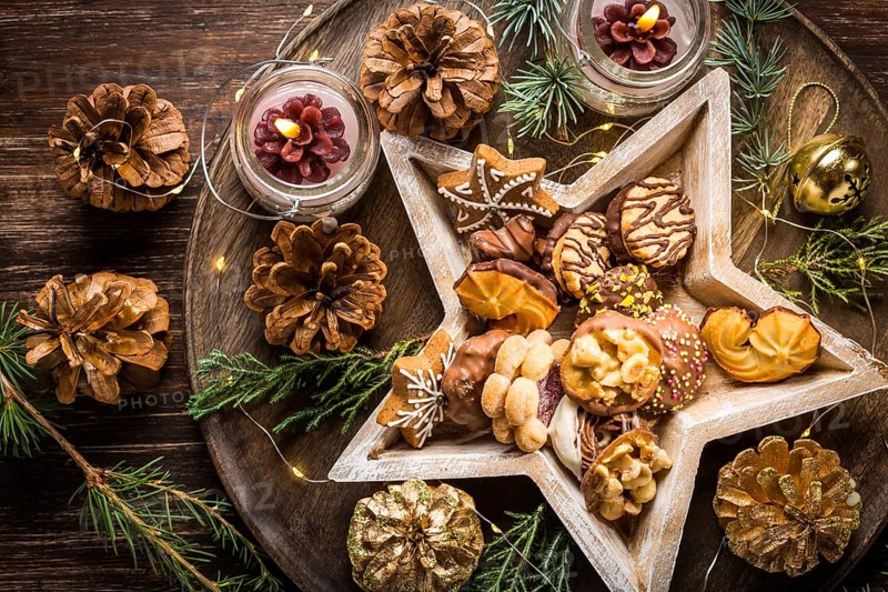 Variation of Christmas cookies and gingerbread with ornaments on wooden background