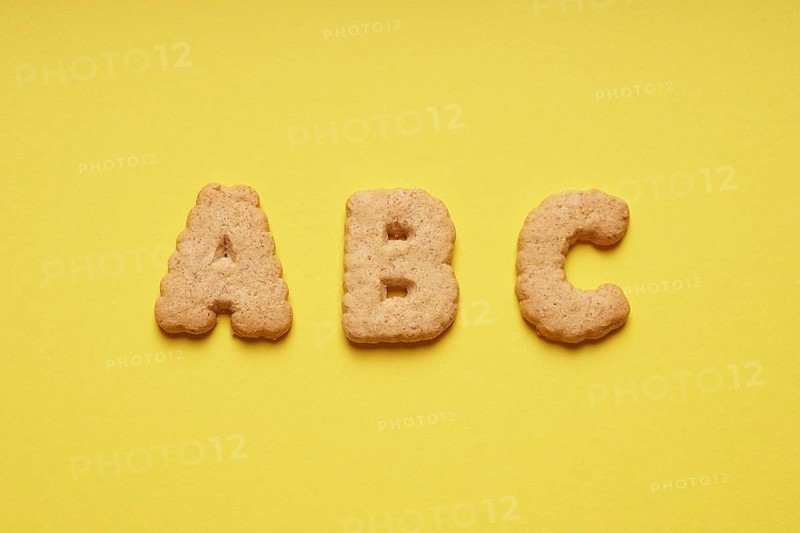ABC cookie or biscuit letters or characters on yellow paper background