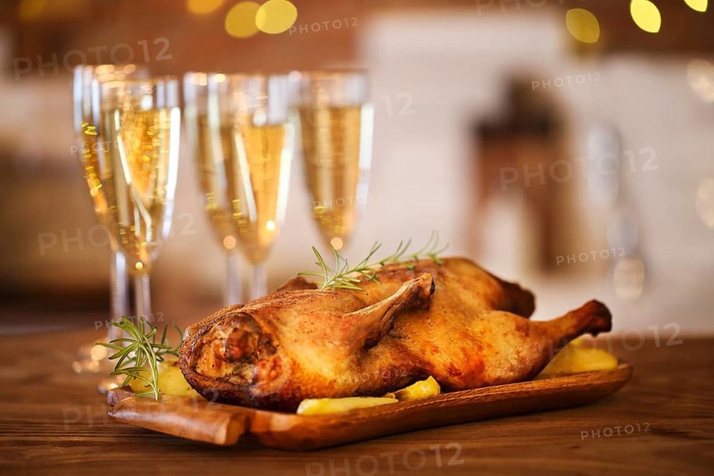 Christmas dinner with roast duck and champagne on wooden table