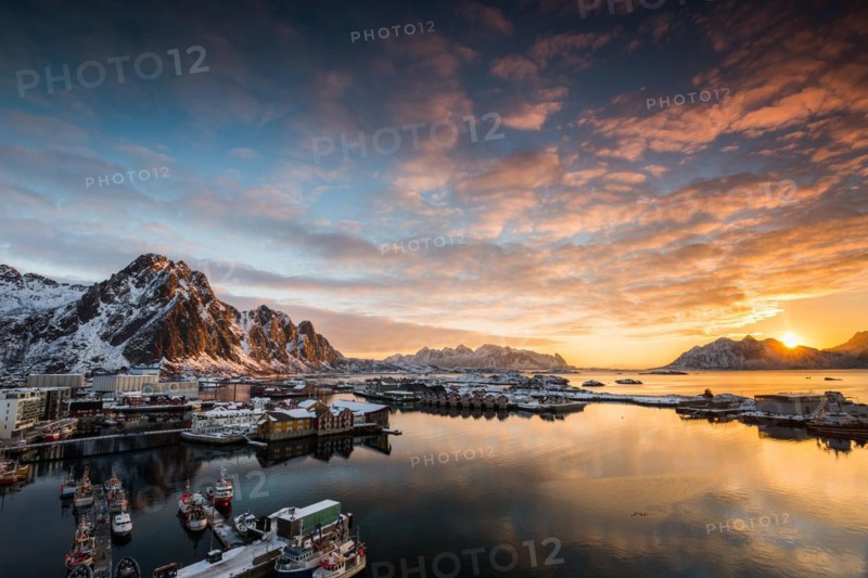 View over the port of Svolvaer on the Lofoten islands in colorful early morning sunrise in winter with snow