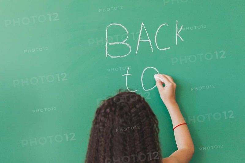 Brunette girl standing chalkboard writing