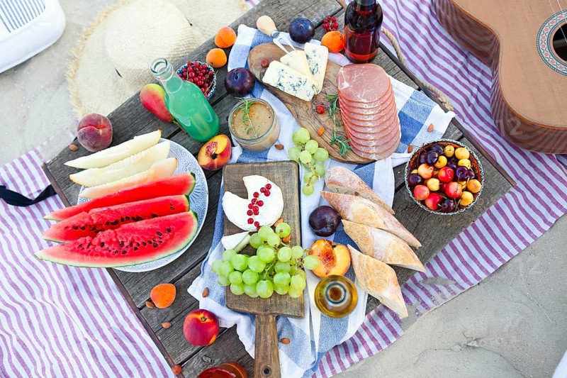 Picnic on the beach at sunset in the style of boho. Food and drink, relax, holiday concept