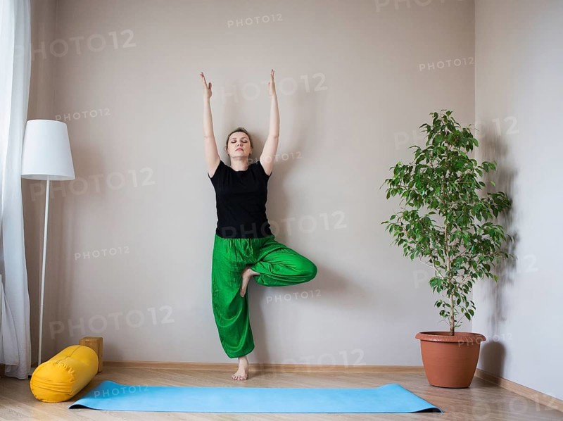 Middle aged or mature woman doing yoga indoors