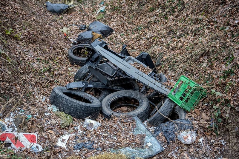 Old used car tires in the forest. Illegal dump of tires in the nature. Environmental pollution
