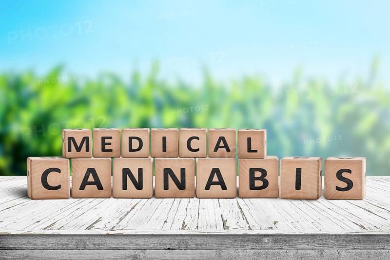 Medical Cannabis sign on a natural desk with a field of herbs in the background