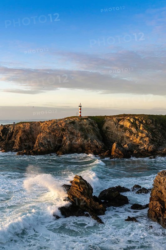 view of the rugged Alentejo coastline and Porto Covo lighthouse at sunset