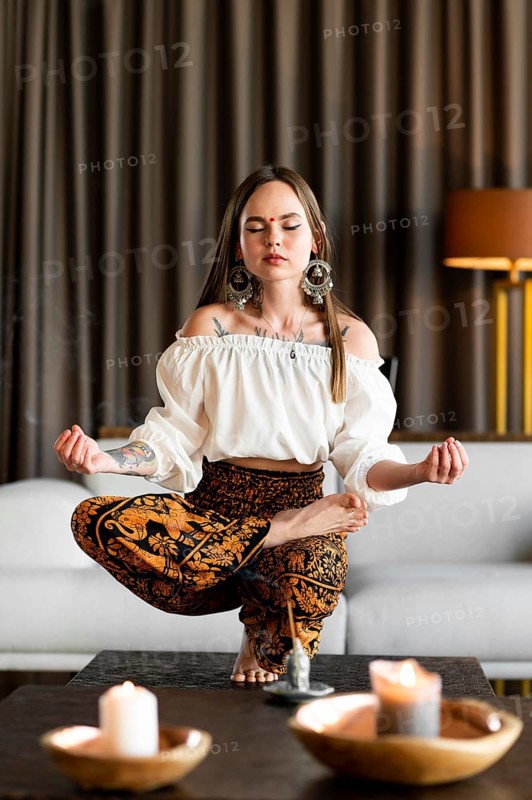 Full shot woman meditating inside
