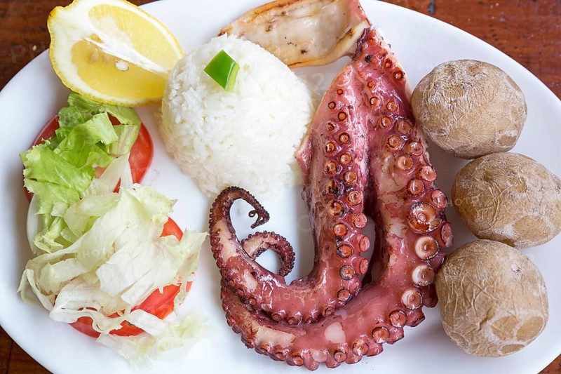 Grilled octopus with side dishes on a plate
