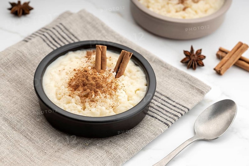 Creamy rice pudding with cinnamon in bowl on white marble table. Typical Spanish dessert