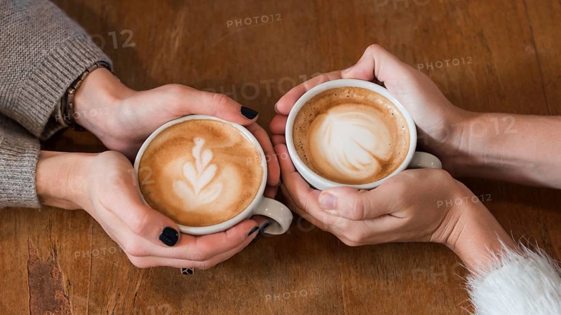 Women holding cups coffee table