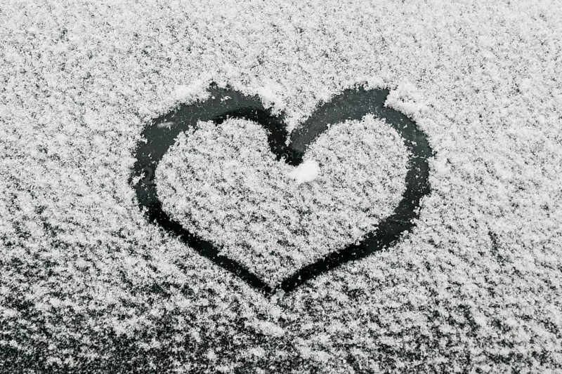 Heart shape snowy glass during winter day