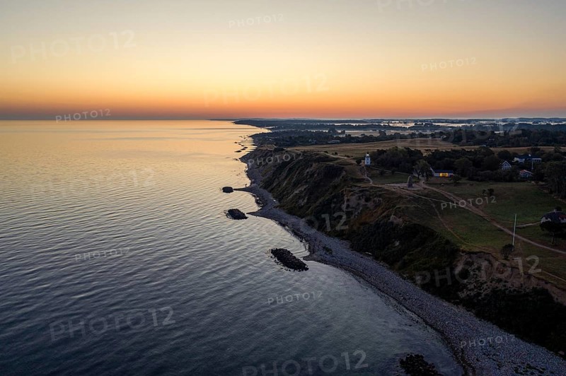 Hundested, Denmark, August 15, 2020: Aerial drone view of Spodsbjerg lighthouse and the coastline during sunrise, Europe