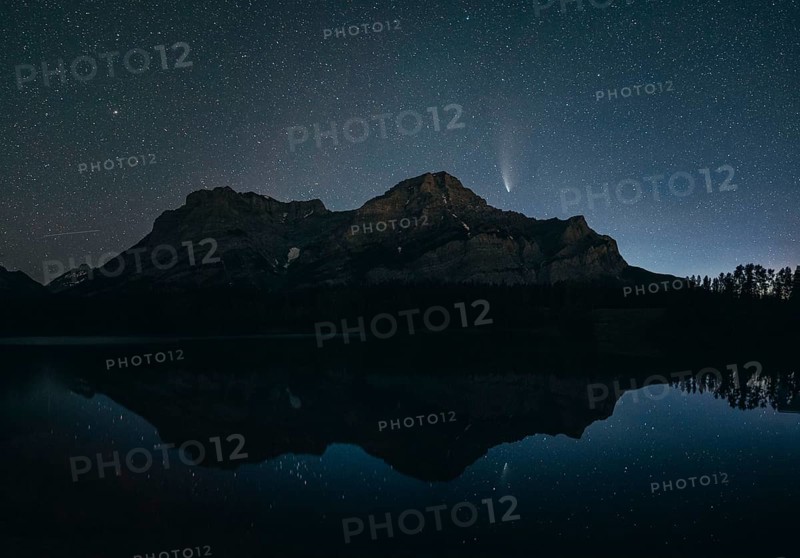 Night sky with stars over a mountain and its reflection in a calm lake, silhouette and a visible comet, Comet Neowise, Kananaskis Country, Alberta, Canada, North America