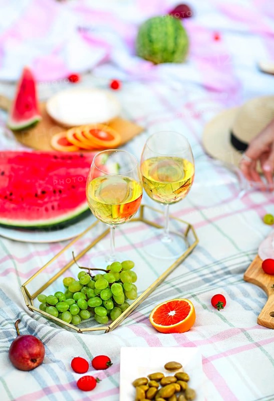 Picnic background with white wine on green grass close-up