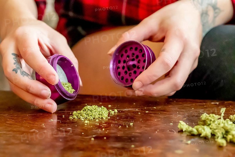 A beautiful brunette model smokes marijuana in the privacy of her own home