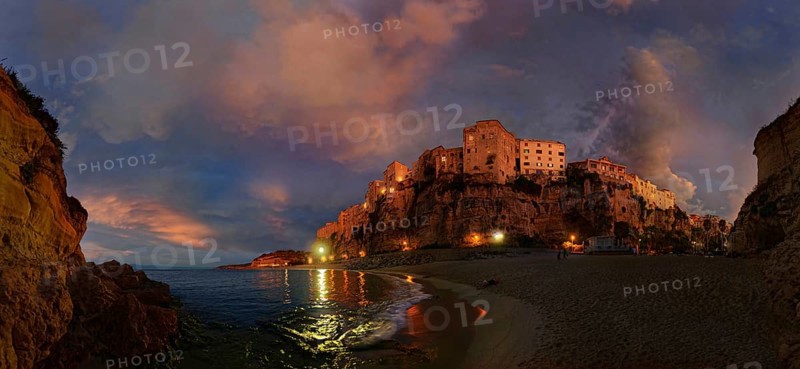 Panorama on the beach Lido Le Roccette Club Tropea with the old town of Tropea perched on sandstone cliffs and the sky lit up with clouds at sunset, Tropea, Vibo Valentia, Calabria, Southern Italy, Italy, Europe