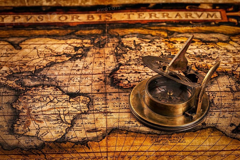 Travel geography navigation concept background, old vintage retro compass with sundial on ancient world map