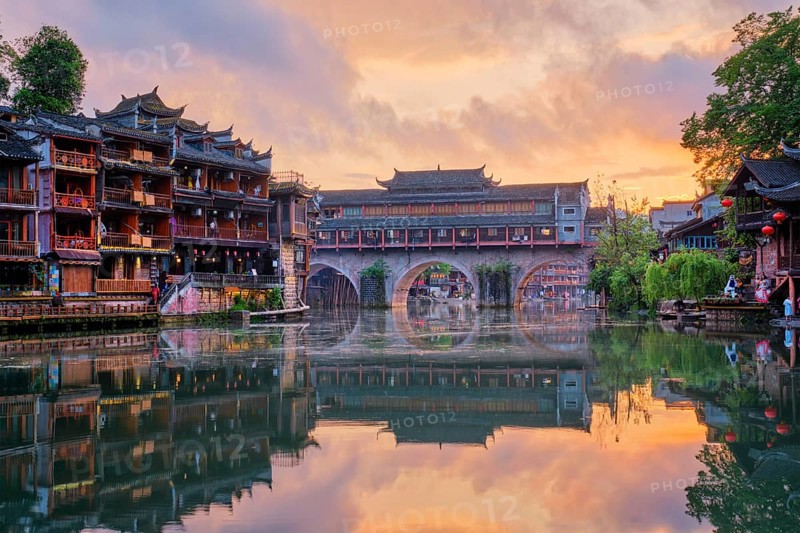 Chinese tourist attraction destination, Feng Huang Ancient Town (Phoenix Ancient Town) on Tuo Jiang River illuminated at night. Hunan Province, China, Asia