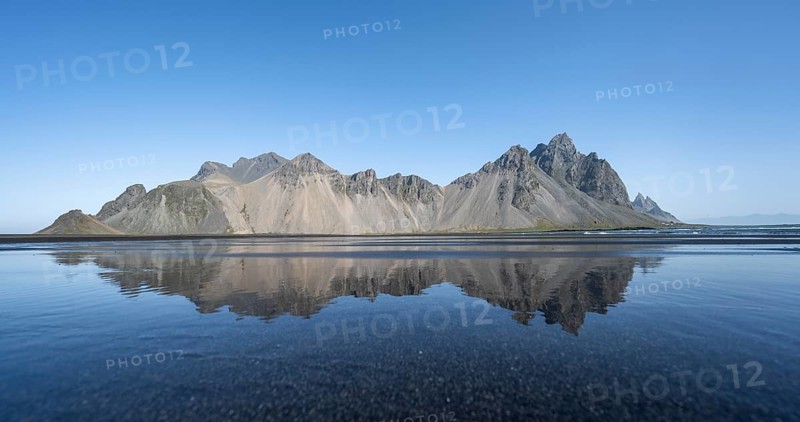 Black lava beach, sandy beach and sea, mountains Klifatindur reflected in the water, Eystrahorn and Kambhorn, headland Stokksnes, mountain range Klifatindur, Austurland, East Iceland, Iceland, Europe