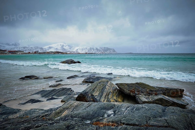 Waves of Norwegian sea on rocky beach of fjord. Ramberg beach, Lofoten islands, Norway, Europe