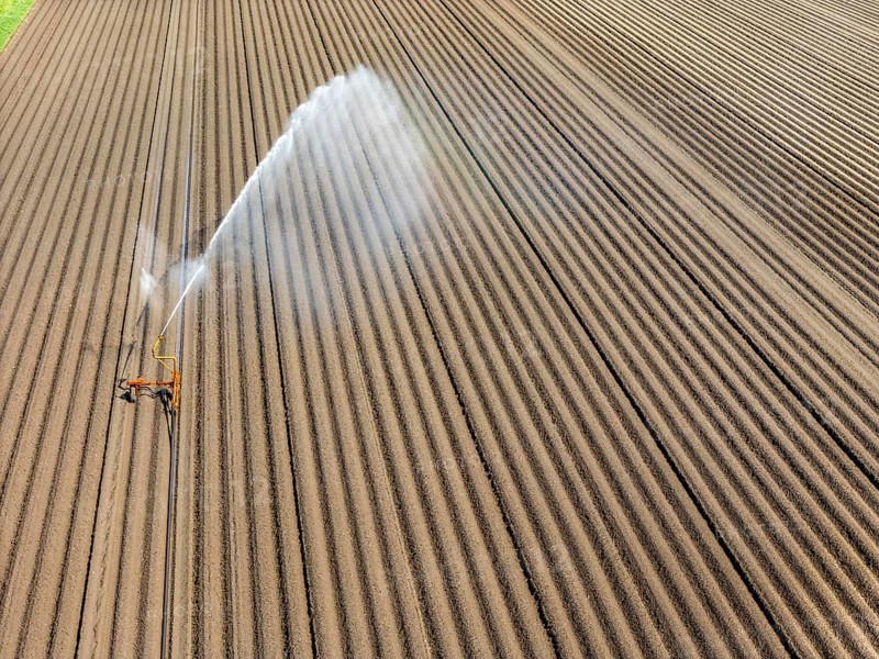 Artificial irrigation of a potato field in April, with a sprinkler system, long drought in spring makes this necessary, for the total of 7.5 hectares 3 full days are needed to get the necessary moisture for the freshly sown potato plants, south of Straelen, Lower Rhine, North Rhine-Westphalia, Germany, Europe