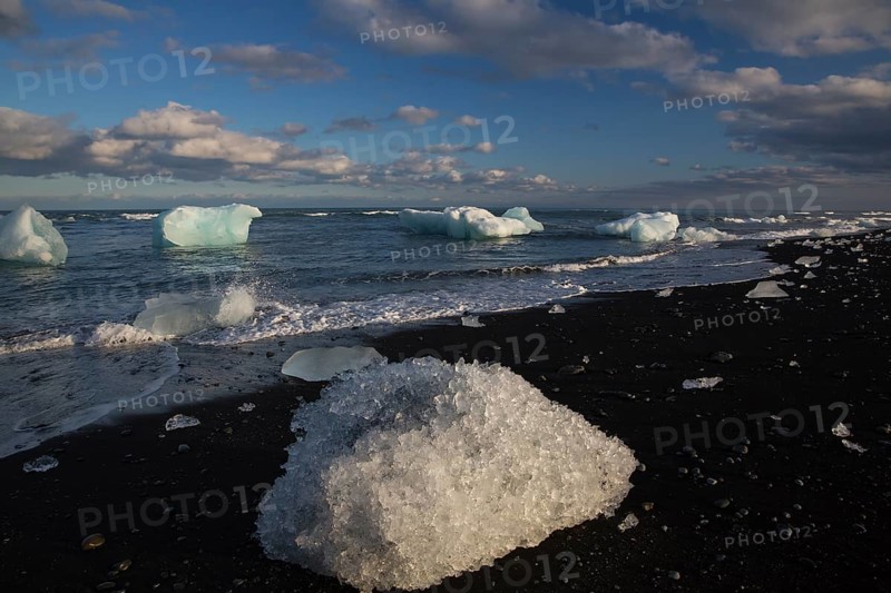 Little icebergs and crushed ice on the black beach at Joekulsarlon glacial lake