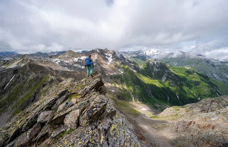 Mountaineer on a steep rocky ridge, on the summit of the Lasörling, view of mountains of the Venediger group, Lasörling group, Hohe Tauern National Park, East Tyrol, Tyrol, Austria, Europe