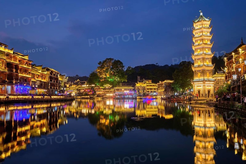 Chinese tourist attraction destination, Feng Huang Ancient Town (Phoenix Ancient Town) on Tuo Jiang River with Wanming Pagoda illuminated at night. Hunan Province, China, Asia