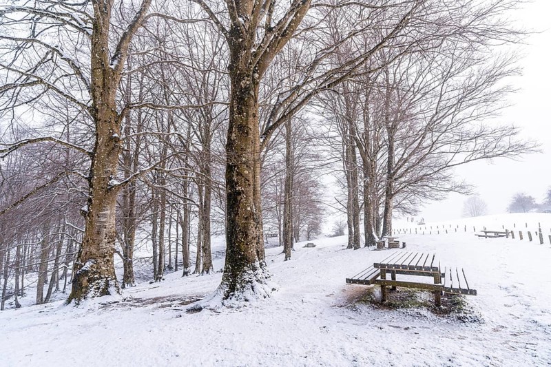 Snowy sunrise at the picnic area next to the refuge of Mount Aizkorri in Gipuzkoa. Snowy landscape by winter snows. Basque Country, Spain, Europe