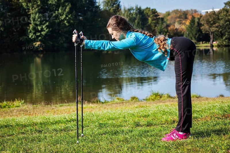 Nordic walking adventure and exercising concept, woman doing exercise with nordic walking poles in park