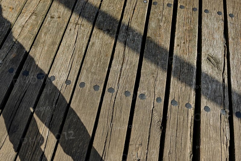 Shadow cast by a person and wooden planks, heritage-protected wooden bascule bridge over the Trebel near Nehringen, Mecklenburg-Western Pomerania, Germany, Europe