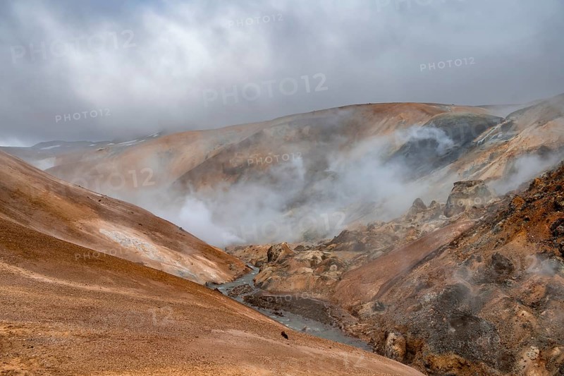 Steaming stream between colourful rhyolite mountains and snowfields, Hveradalir geothermal area, Kerlingarfjöll, Icelandic Highlands, Iceland, Europe