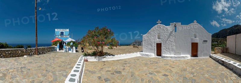 Café Skopi with small white church Parekkl?sia under a blue sky with a quiet Mediterranean atmosphere and a cobbled stone path, Mesochori, Karpathos, South Aegean, Greece, Europe